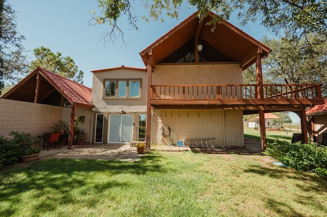 rear view of property with a patio, a deck, and a lawn