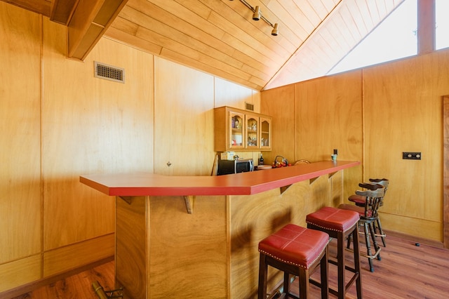 bar with hardwood / wood-style floors, wooden walls, lofted ceiling, and wood ceiling