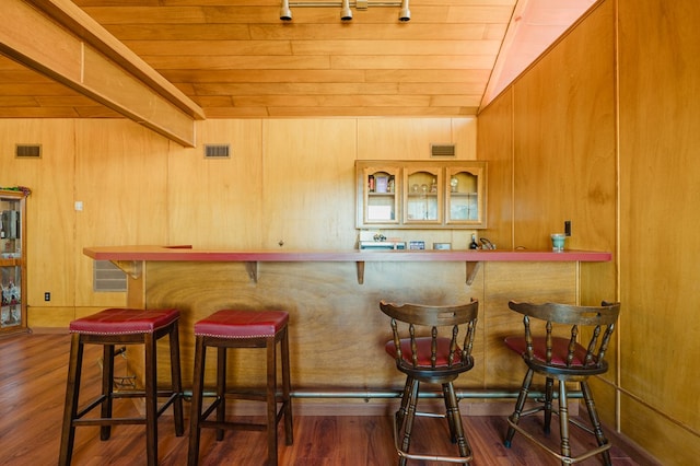 bar featuring dark hardwood / wood-style floors and wood walls