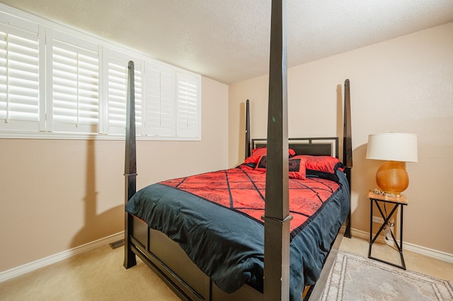 bedroom with light carpet and a textured ceiling