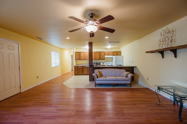 living room featuring ceiling fan and light hardwood / wood-style flooring