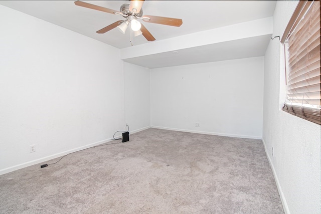 spare room featuring light colored carpet and ceiling fan