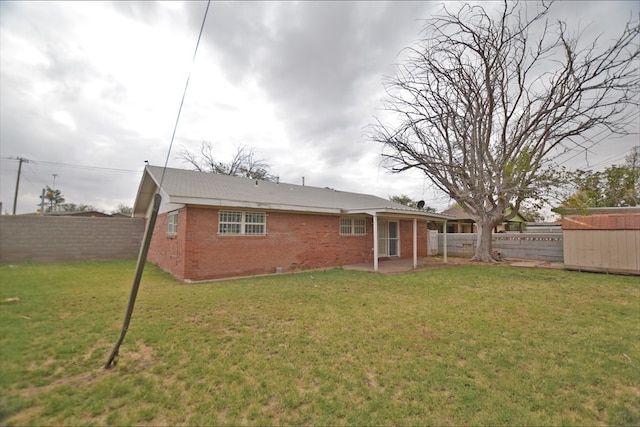 rear view of house with a yard and a storage shed