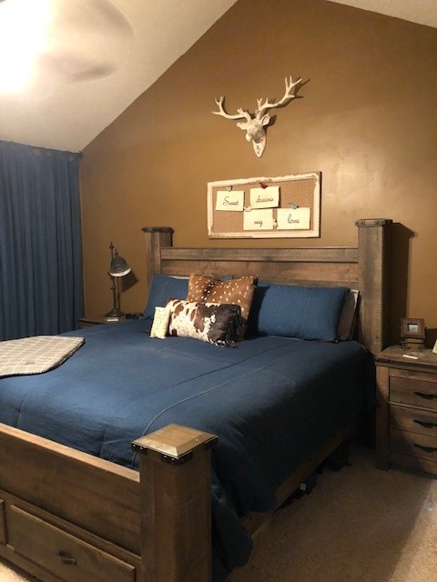 carpeted bedroom with vaulted ceiling