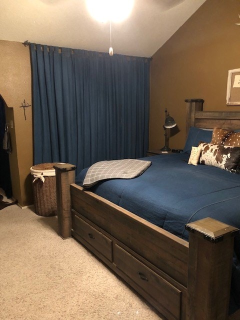 bedroom with carpet flooring and vaulted ceiling