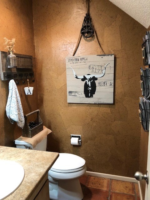 bathroom featuring vanity, a textured ceiling, and toilet