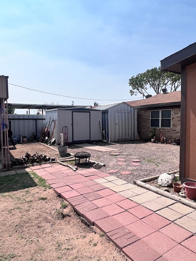 view of patio / terrace with a shed and a fire pit