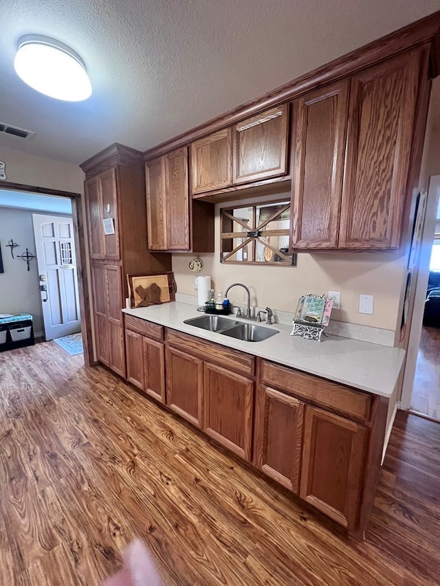 kitchen featuring dark hardwood / wood-style flooring, sink, and a textured ceiling