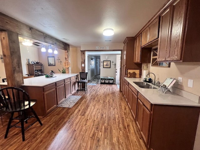 kitchen with a textured ceiling, dark hardwood / wood-style flooring, ceiling fan, and sink