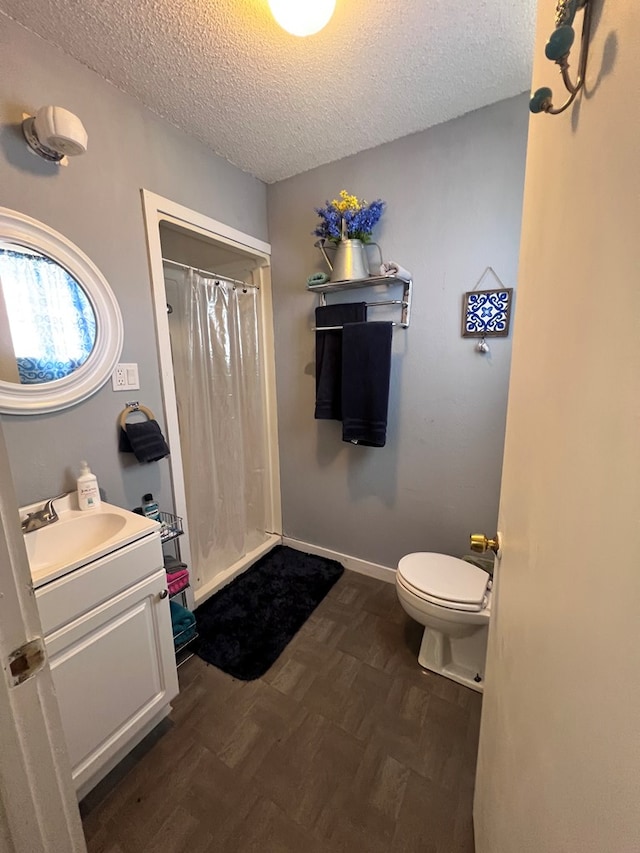 bathroom with a shower with shower curtain, vanity, toilet, and a textured ceiling