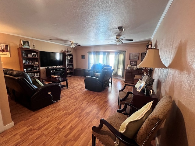 living room with wood-type flooring, a textured ceiling, and ornamental molding