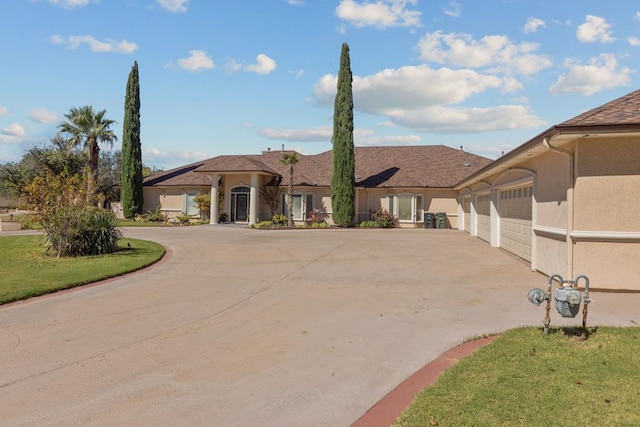 mediterranean / spanish home with a garage and a front lawn