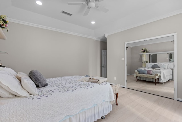 bedroom featuring ceiling fan, a closet, light hardwood / wood-style floors, and ornamental molding