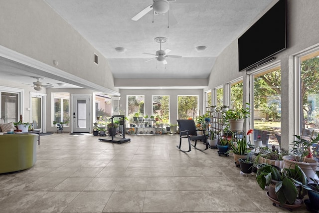 sunroom with ceiling fan, plenty of natural light, and vaulted ceiling