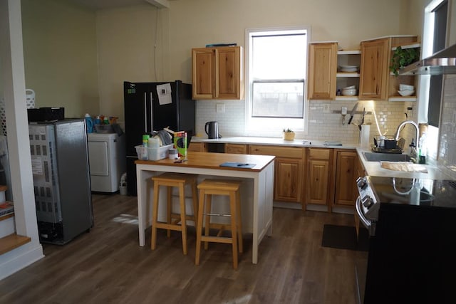 kitchen featuring dark wood-type flooring, black electric range oven, sink, and exhaust hood