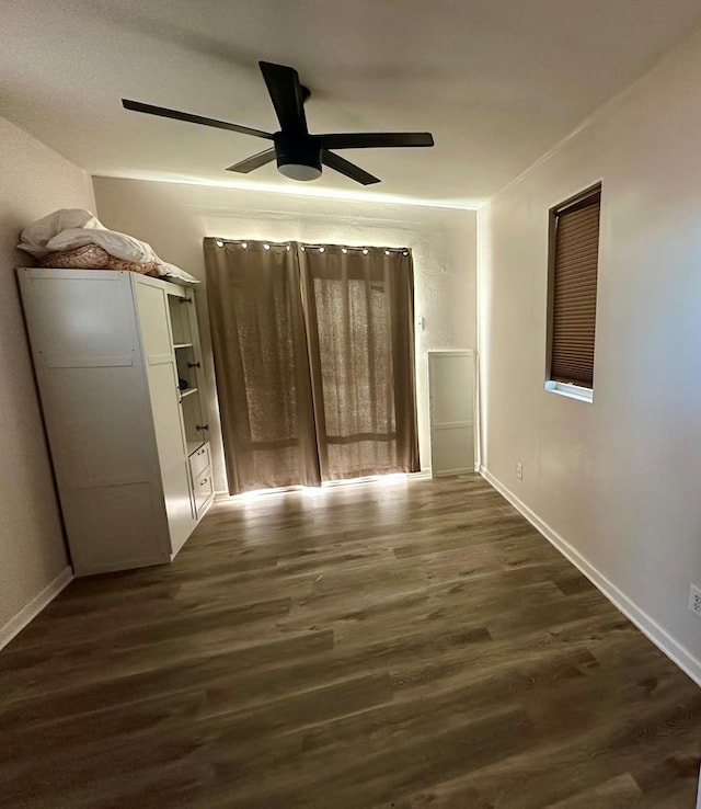 unfurnished room with dark wood-type flooring and ceiling fan