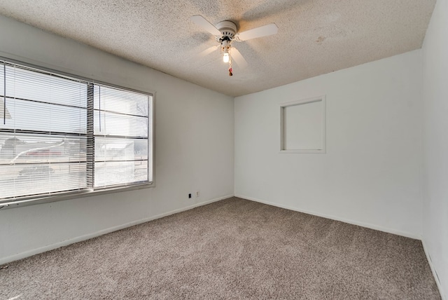 carpeted empty room featuring ceiling fan and a textured ceiling