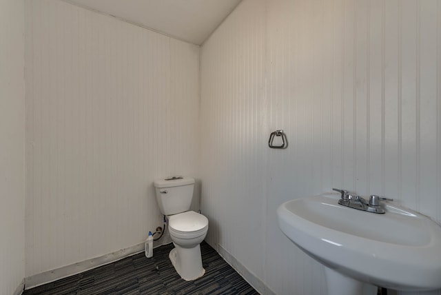 bathroom with toilet, tile patterned flooring, and sink