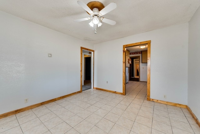 tiled empty room with a textured ceiling and ceiling fan