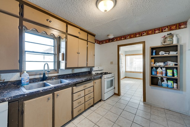 kitchen with sink, white range with gas stovetop, a textured ceiling, and light tile patterned floors