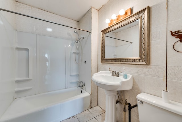 full bathroom with tile patterned floors, toilet, bathtub / shower combination, sink, and tile walls