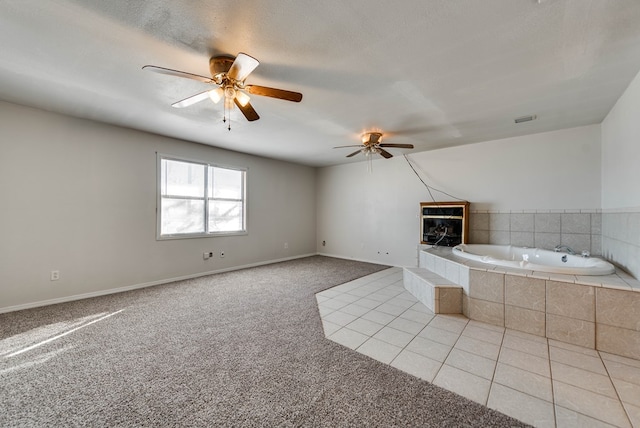 bathroom featuring tile patterned flooring, a textured ceiling, a tile fireplace, and ceiling fan