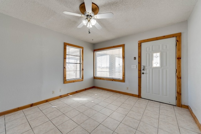 foyer entrance with light tile patterned floors, a textured ceiling, and ceiling fan