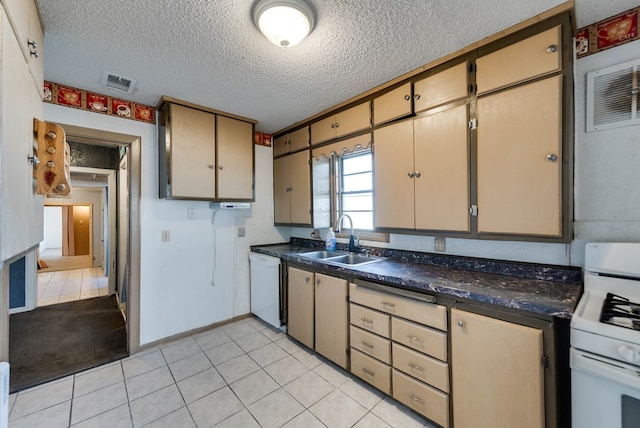 kitchen featuring sink, light tile patterned floors, a textured ceiling, and white appliances