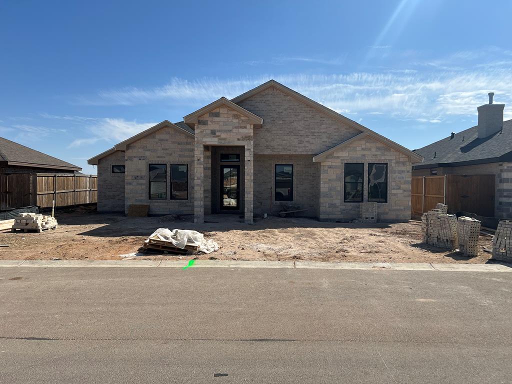 unfinished property with brick siding and fence