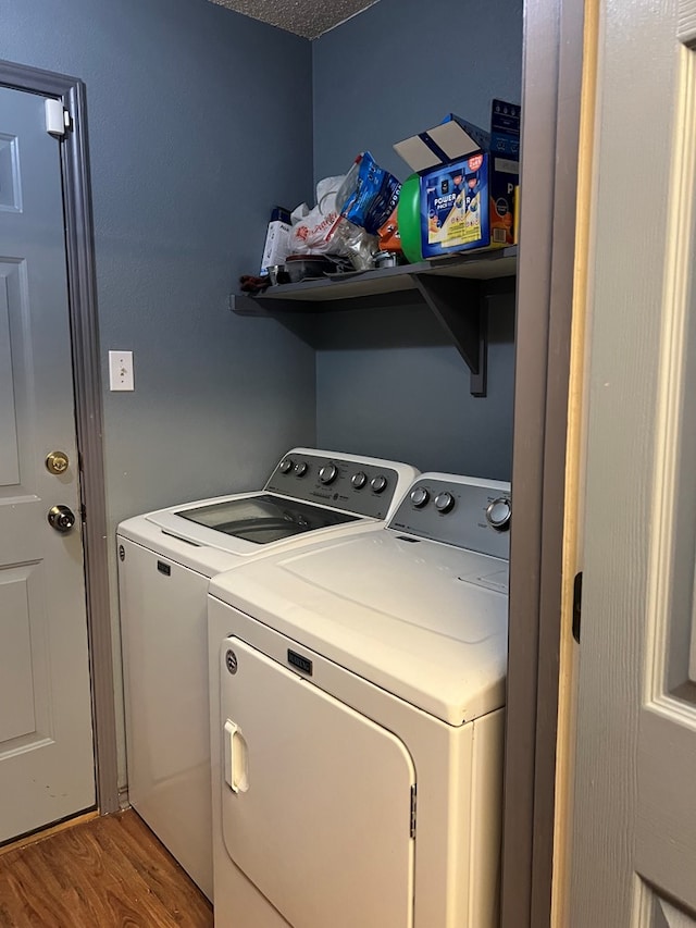 laundry room featuring hardwood / wood-style floors, separate washer and dryer, and a textured ceiling