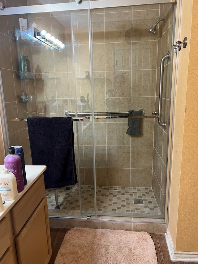 bathroom featuring vanity, an enclosed shower, and hardwood / wood-style flooring