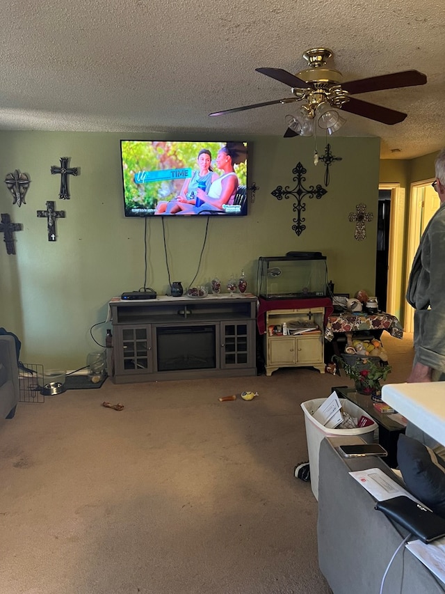 living room with ceiling fan, carpet floors, and a textured ceiling