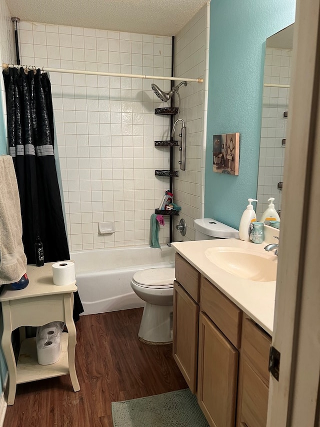 full bathroom with shower / bath combo, vanity, a textured ceiling, wood-type flooring, and toilet