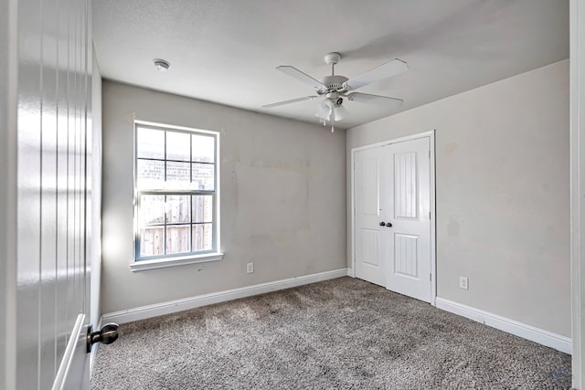 empty room with ceiling fan and carpet flooring