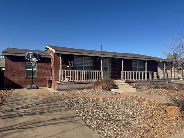 single story home featuring a porch and brick siding