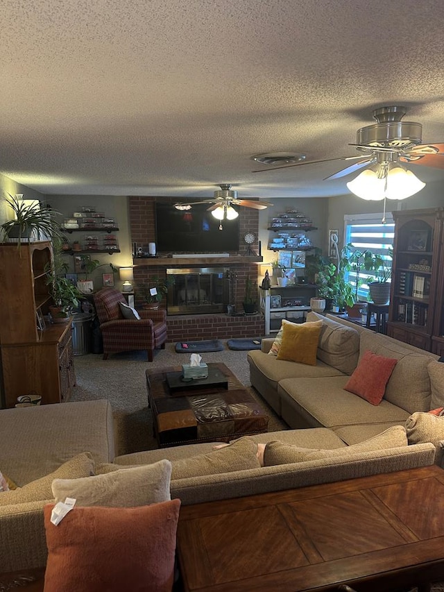 carpeted living room with a textured ceiling, a brick fireplace, and a ceiling fan