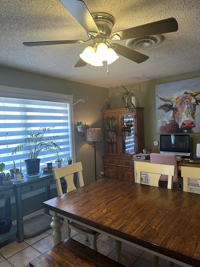 dining area featuring a ceiling fan, a textured ceiling, and light tile patterned flooring