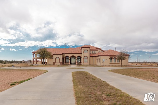 view of front of property with stucco siding and curved driveway