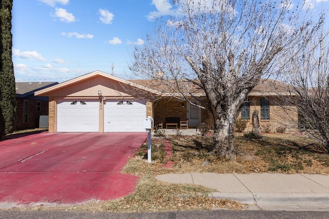 ranch-style home with driveway, a garage, and brick siding