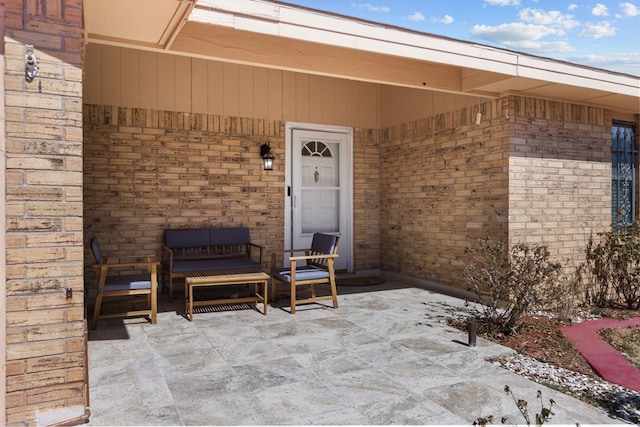 property entrance featuring brick siding and a patio area