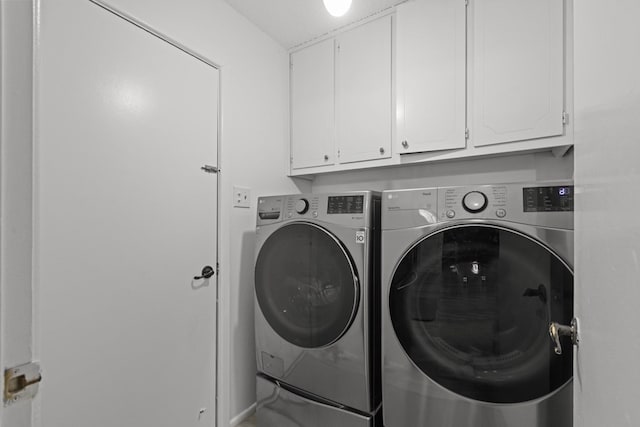 laundry area with washing machine and clothes dryer and cabinet space