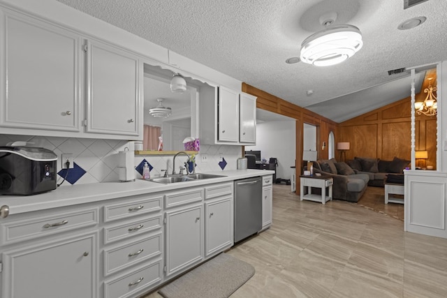 kitchen featuring a sink, vaulted ceiling, light countertops, decorative backsplash, and dishwasher