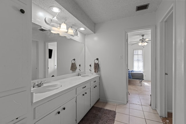 full bath featuring a textured ceiling, tile patterned flooring, a sink, and visible vents