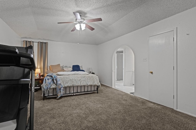 carpeted bedroom with a ceiling fan, arched walkways, and a textured ceiling