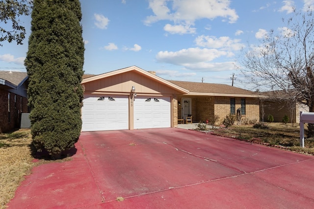 single story home featuring driveway, brick siding, central AC, and an attached garage