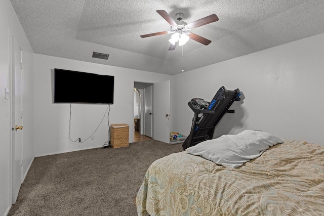 carpeted bedroom featuring a ceiling fan, visible vents, and a textured ceiling