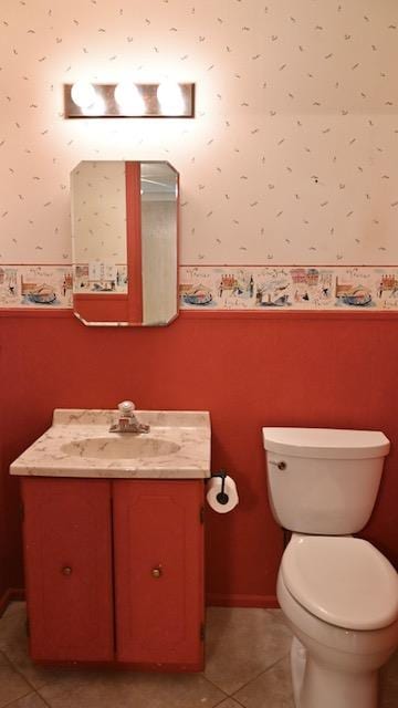 bathroom with toilet, vanity, and tile patterned floors