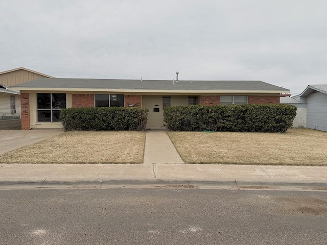 single story home featuring brick siding