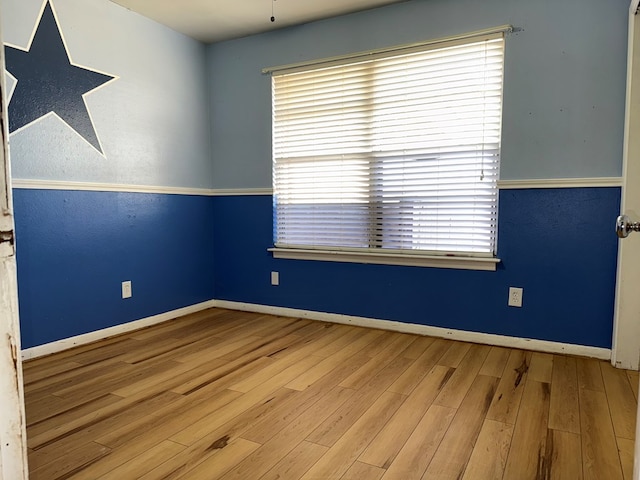 spare room with wood finished floors and baseboards