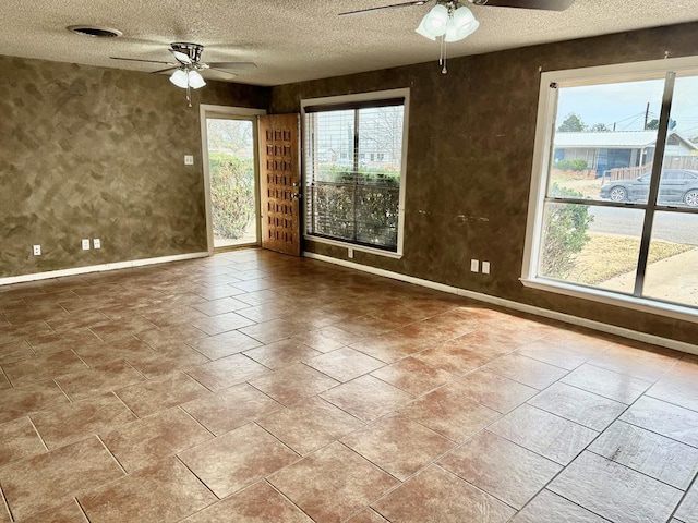 unfurnished room featuring baseboards, a textured ceiling, and a ceiling fan